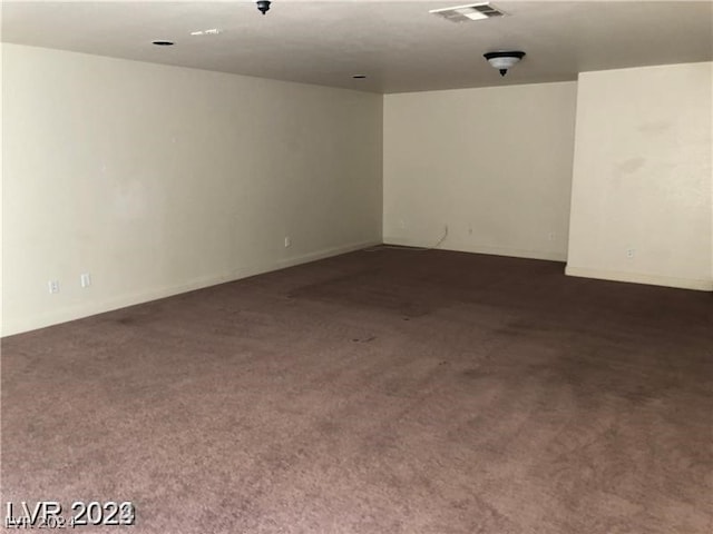 spare room featuring dark colored carpet