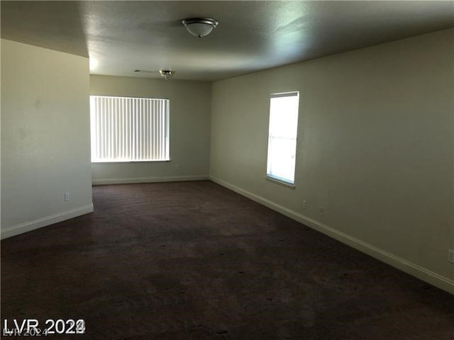 spare room with dark colored carpet