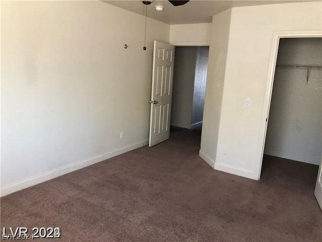 unfurnished bedroom with a closet and dark carpet