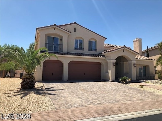 mediterranean / spanish-style home with a garage and central air condition unit