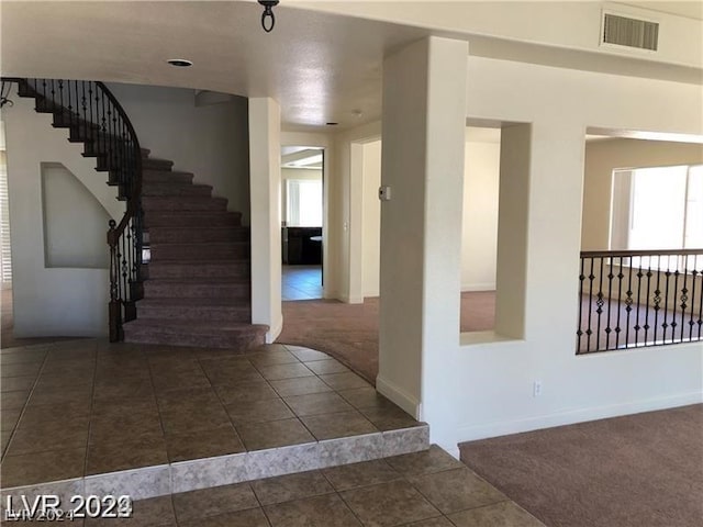 foyer featuring dark tile flooring