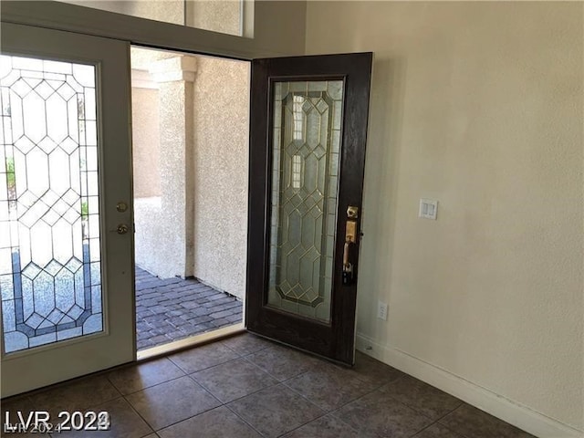 foyer entrance featuring dark tile flooring