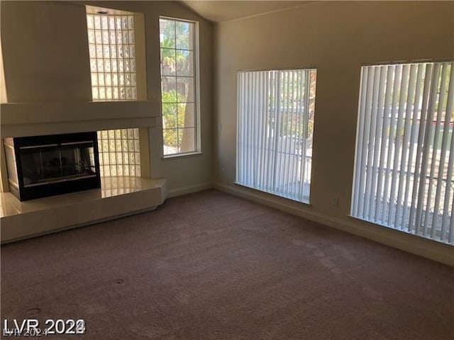 unfurnished living room featuring plenty of natural light and carpet