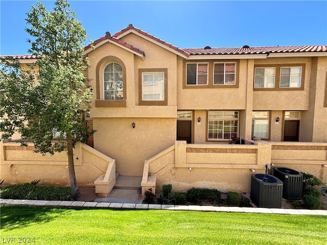 view of front of property with a front yard and central air condition unit