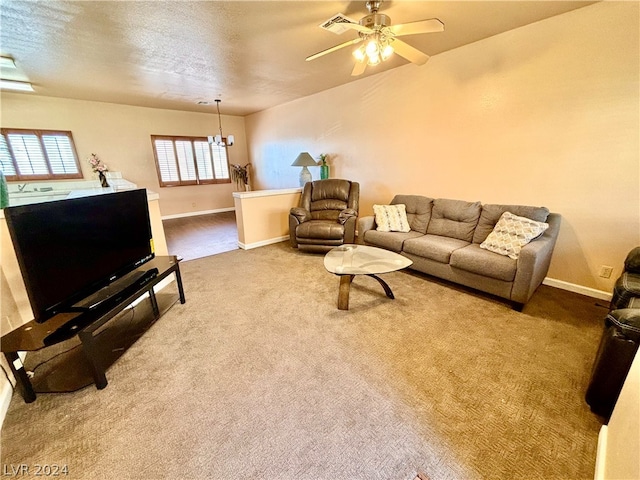 living room with light colored carpet, ceiling fan, and a textured ceiling