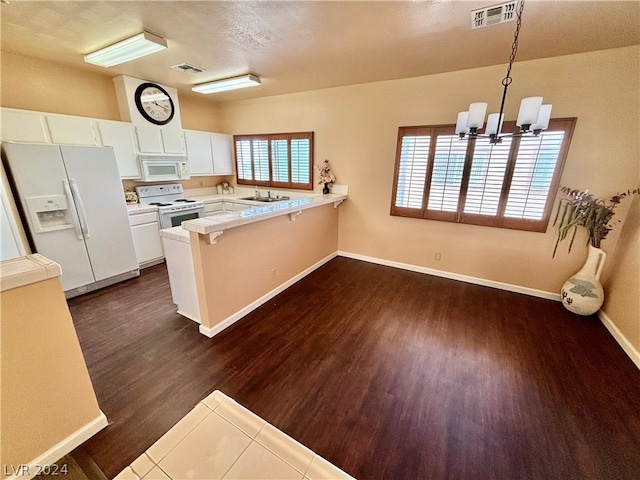 kitchen featuring white appliances, white cabinetry, sink, dark hardwood / wood-style flooring, and a chandelier