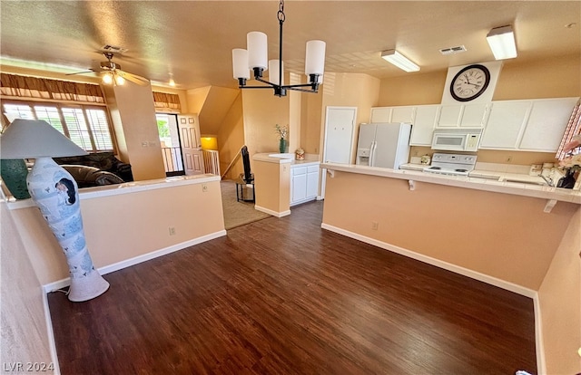 kitchen with pendant lighting, white cabinets, white appliances, ceiling fan with notable chandelier, and dark wood-type flooring