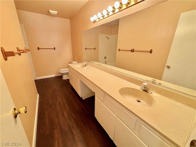 bathroom with hardwood / wood-style flooring, double sink, toilet, and oversized vanity