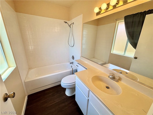 full bathroom with tiled shower / bath combo, large vanity, toilet, and hardwood / wood-style flooring