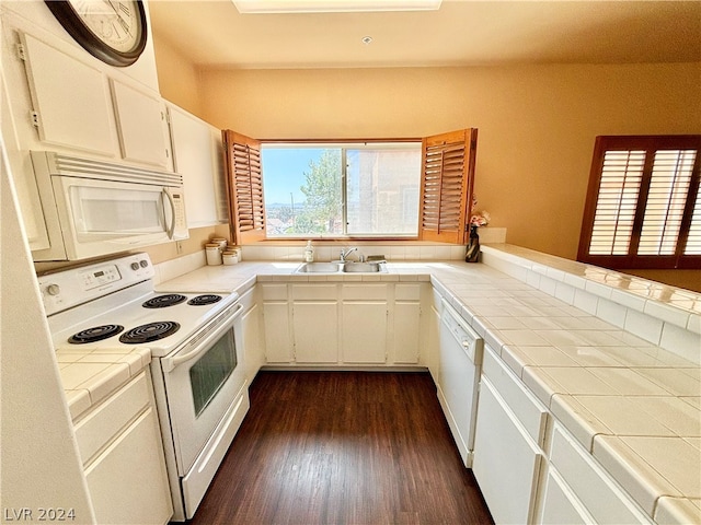 kitchen with dark hardwood / wood-style floors, white cabinets, white appliances, and sink