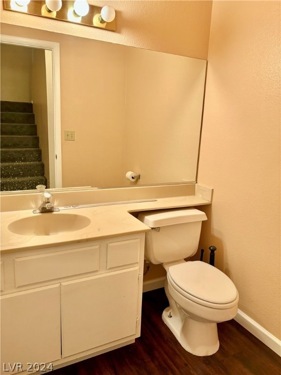 bathroom with hardwood / wood-style floors, vanity, and toilet