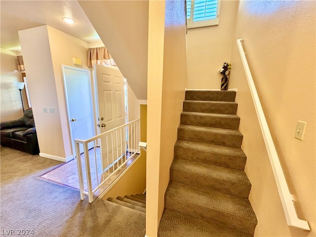 stairs featuring light colored carpet