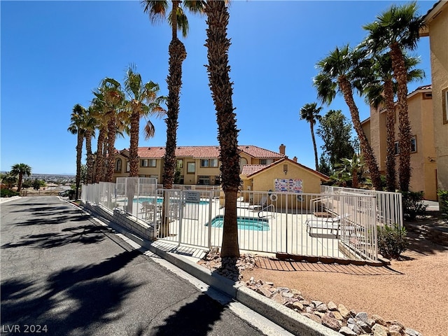 view of front facade with a community pool and a patio area