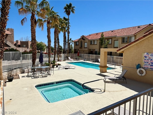 view of swimming pool featuring a hot tub and a patio