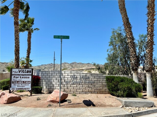 community / neighborhood sign with a mountain view