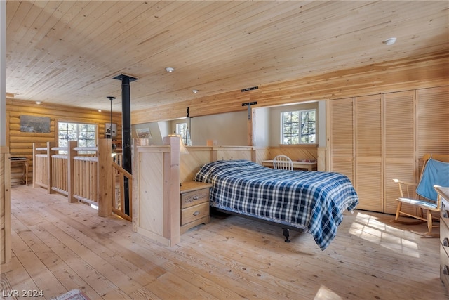 bedroom featuring wood ceiling, a wood stove, light hardwood / wood-style floors, and log walls