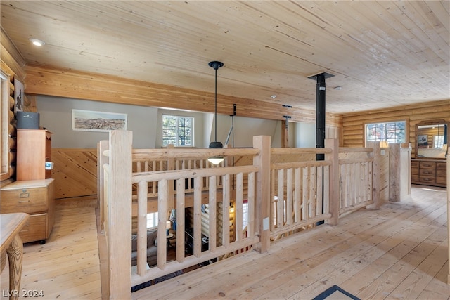 hall featuring wood ceiling, light hardwood / wood-style flooring, and rustic walls