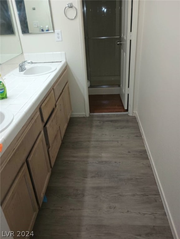 bathroom featuring walk in shower, double sink vanity, and hardwood / wood-style floors