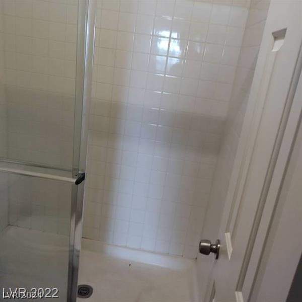 bathroom with a shower with door