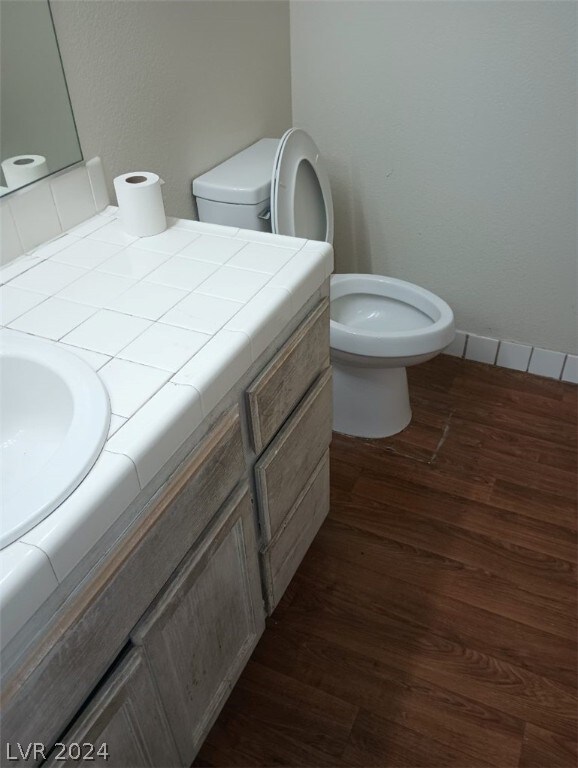 bathroom featuring vanity, toilet, and hardwood / wood-style floors