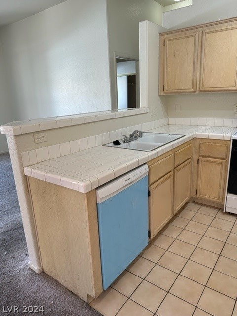 kitchen featuring tile countertops, sink, light brown cabinets, and stainless steel dishwasher