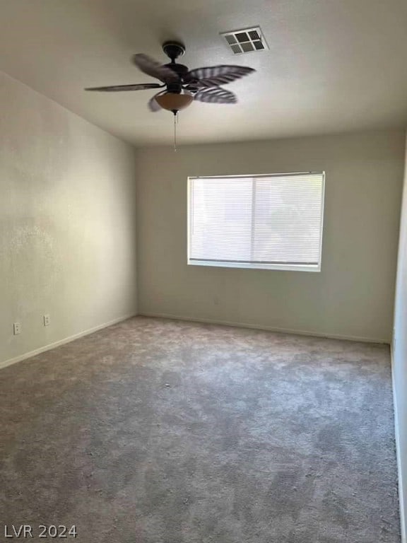 carpeted spare room with ceiling fan