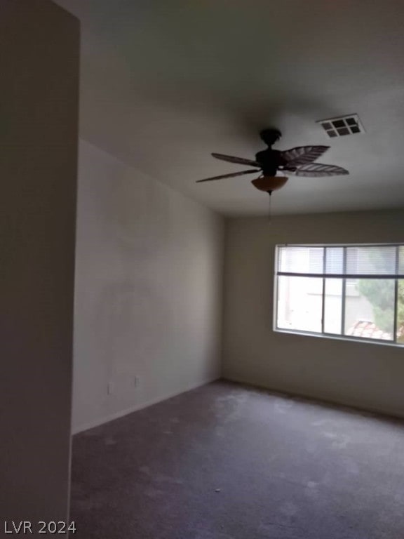 unfurnished room featuring dark carpet and ceiling fan