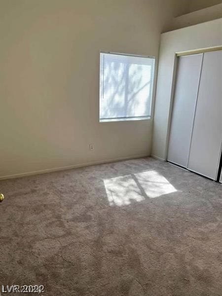 unfurnished bedroom featuring light colored carpet and a closet