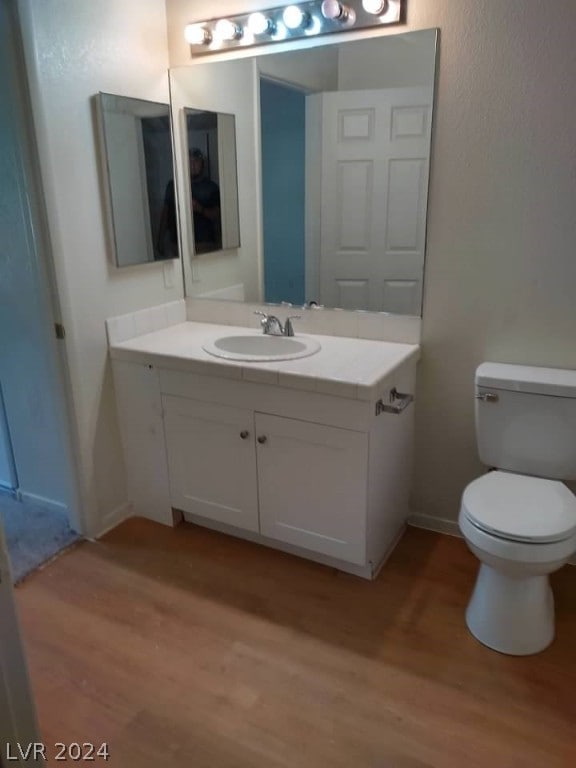 bathroom featuring hardwood / wood-style floors, vanity, and toilet