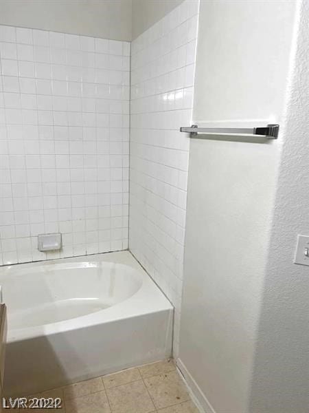 bathroom featuring tiled shower / bath and tile floors