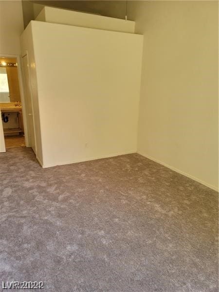 carpeted empty room featuring a high ceiling