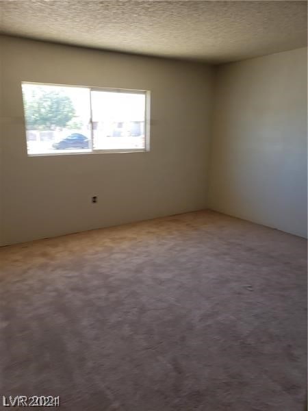 carpeted spare room featuring a textured ceiling