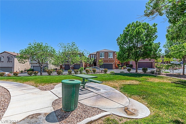 surrounding community with a garage and a lawn