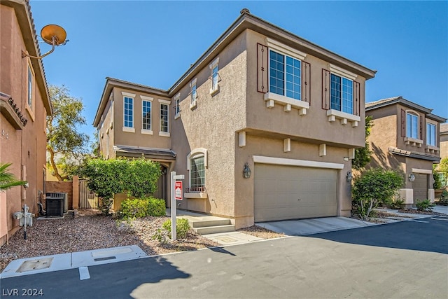 view of front of home with a garage and central AC unit