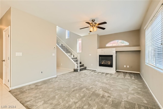 unfurnished living room featuring carpet flooring, ceiling fan, and a premium fireplace