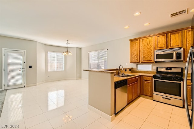 kitchen featuring kitchen peninsula, stainless steel appliances, light tile flooring, sink, and a chandelier