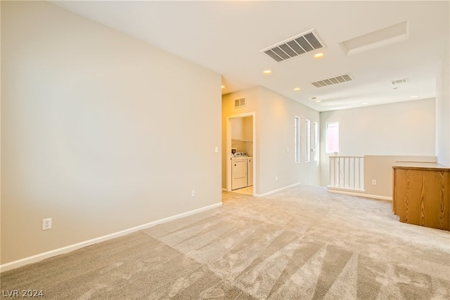 empty room with light colored carpet and independent washer and dryer