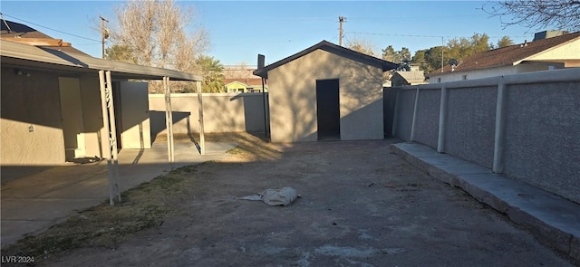 view of yard featuring a fenced backyard, an outdoor structure, and a storage unit