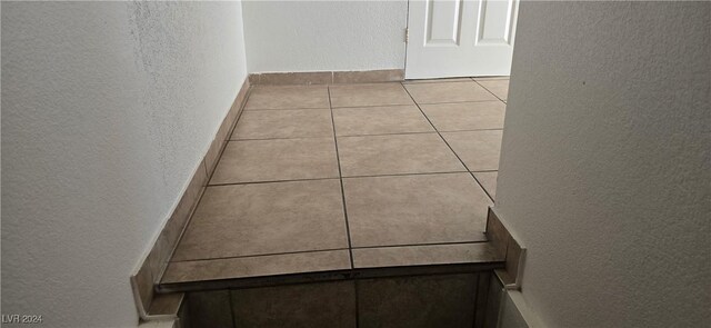 interior space featuring a textured wall and light tile patterned flooring