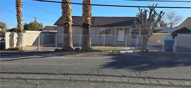 view of front of property with a fenced front yard, roof with shingles, and stucco siding