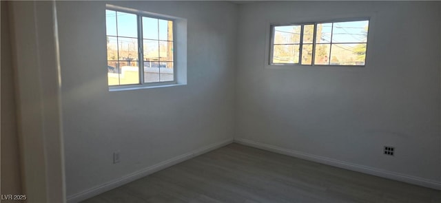 unfurnished room with baseboards and wood finished floors