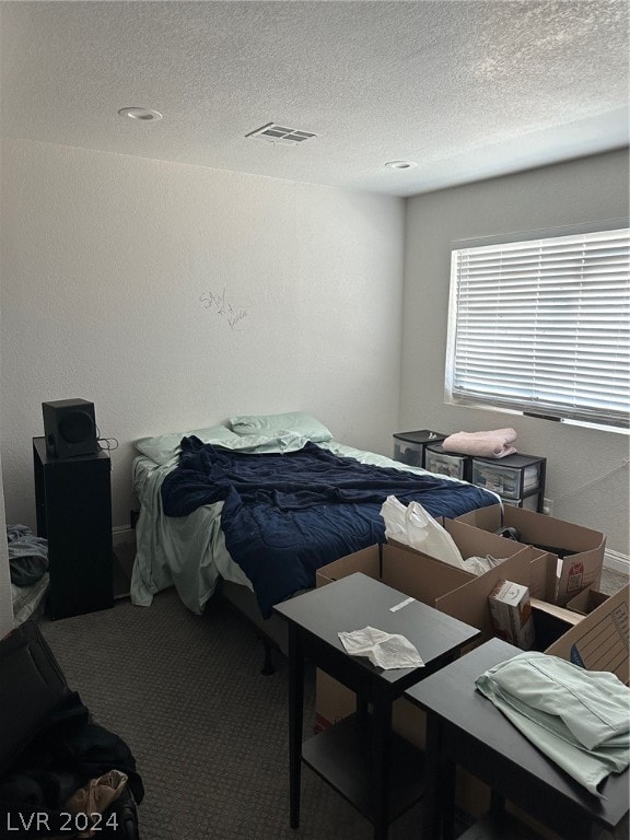 carpeted bedroom featuring a textured ceiling