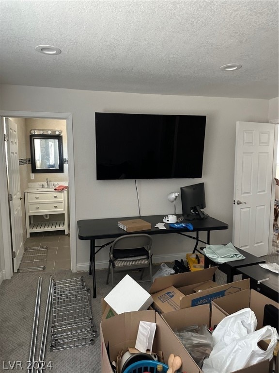 carpeted living room with sink and a textured ceiling