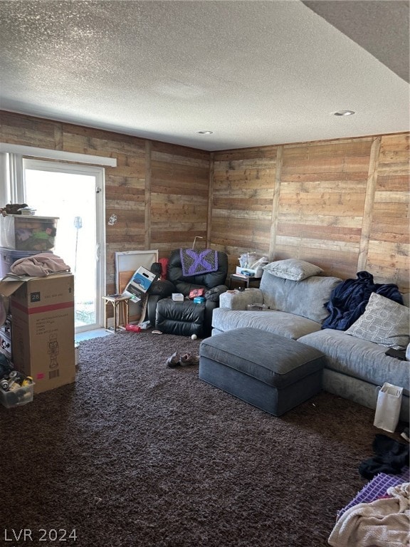 living room with wood walls, carpet floors, and a textured ceiling