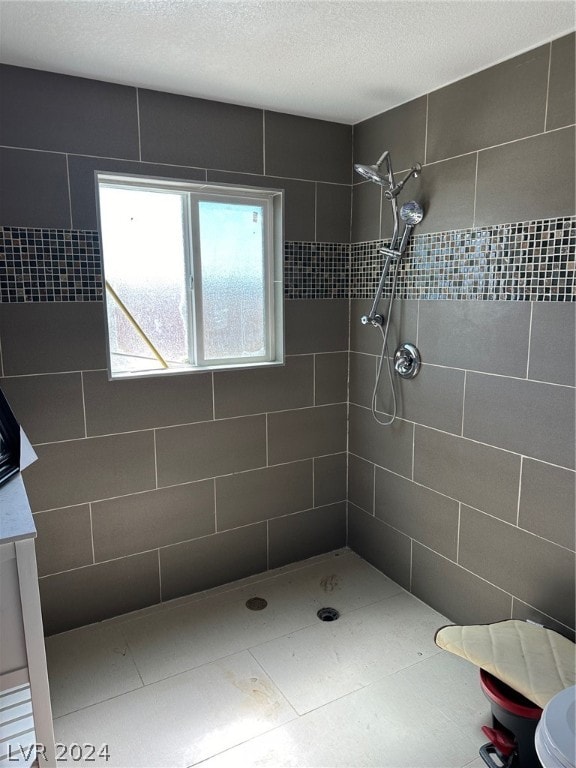 bathroom featuring a textured ceiling, vanity, toilet, and a tile shower