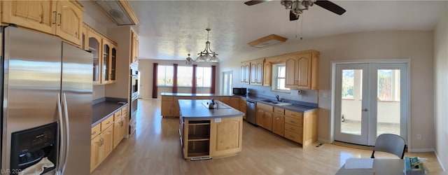 kitchen featuring decorative light fixtures, ceiling fan with notable chandelier, light hardwood / wood-style flooring, stainless steel appliances, and sink