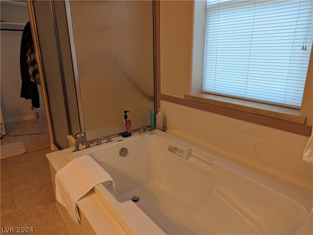 bathroom featuring tile flooring and a tub