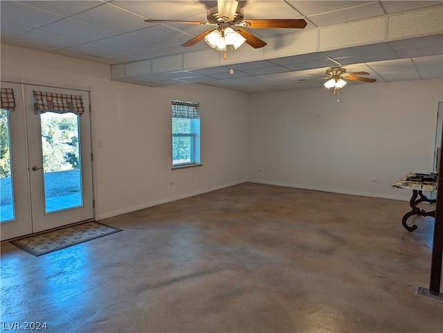 spare room with a drop ceiling, a wealth of natural light, ceiling fan, and french doors