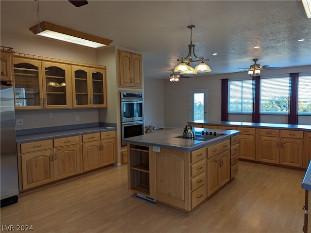 kitchen with hanging light fixtures, ceiling fan, light wood-type flooring, and stainless steel appliances