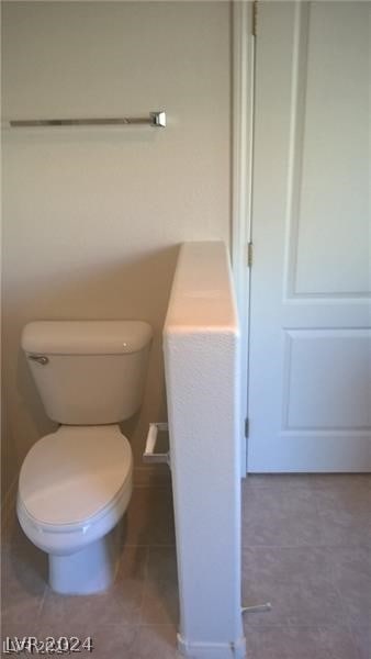 bathroom with toilet and tile flooring